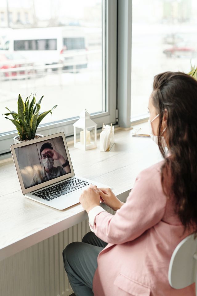A patient on a video telehealth visit with Dr. Huffman on a laptop